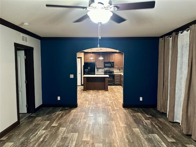 kitchen featuring decorative backsplash, ceiling fan, black appliances, a center island, and dark hardwood / wood-style floors