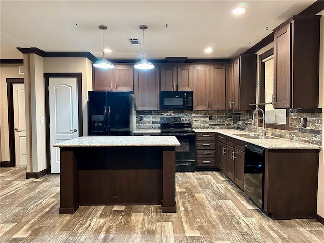 kitchen featuring tasteful backsplash, black appliances, light hardwood / wood-style flooring, a kitchen island, and hanging light fixtures