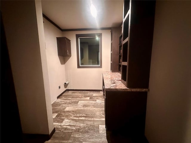 laundry room featuring light wood-type flooring and crown molding