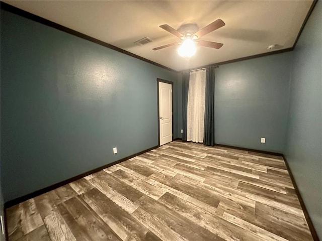 unfurnished room featuring hardwood / wood-style flooring, ceiling fan, and crown molding