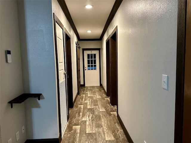 hall with hardwood / wood-style flooring and ornamental molding