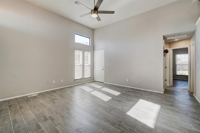 empty room with hardwood / wood-style floors, plenty of natural light, and ceiling fan