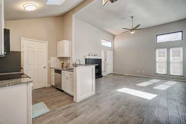 kitchen with high vaulted ceiling, white cabinetry, and a wealth of natural light