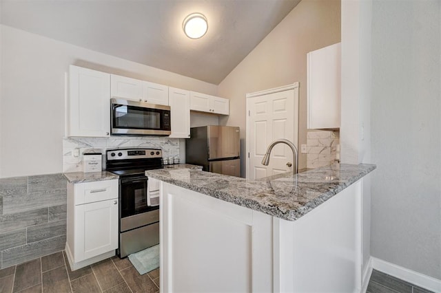 kitchen featuring white cabinets, appliances with stainless steel finishes, kitchen peninsula, and lofted ceiling