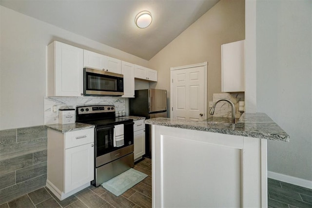 kitchen with kitchen peninsula, white cabinetry, stainless steel appliances, and lofted ceiling