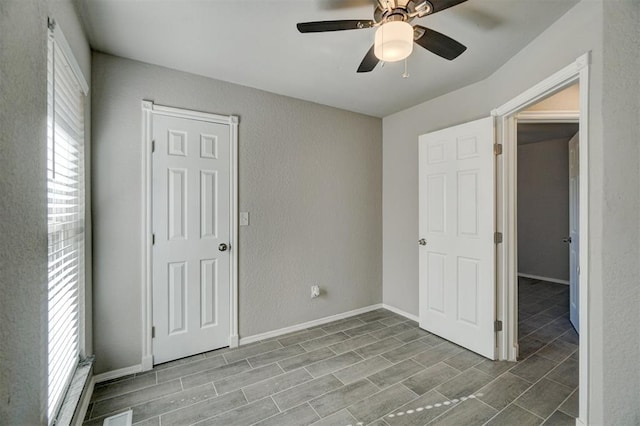 unfurnished bedroom featuring multiple windows, ceiling fan, and hardwood / wood-style floors