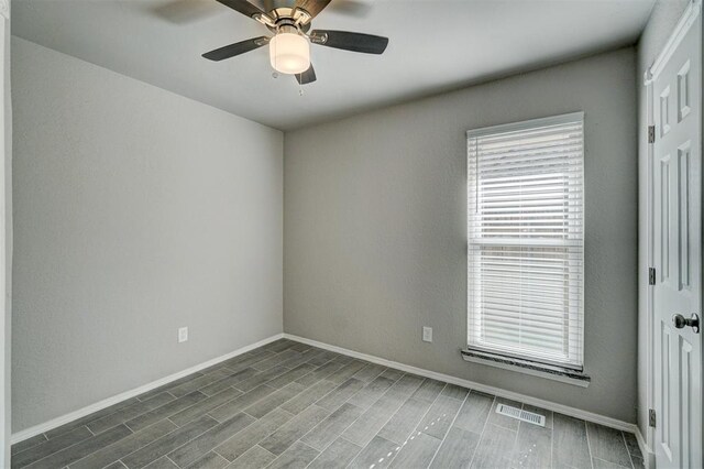 spare room with dark hardwood / wood-style flooring and ceiling fan