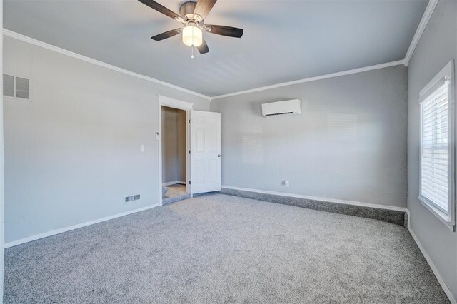 empty room featuring a wall mounted air conditioner, ceiling fan, ornamental molding, and carpet