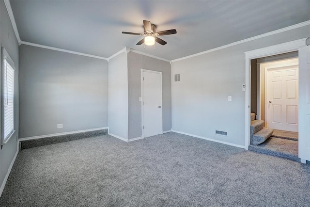 carpeted spare room featuring ceiling fan and crown molding