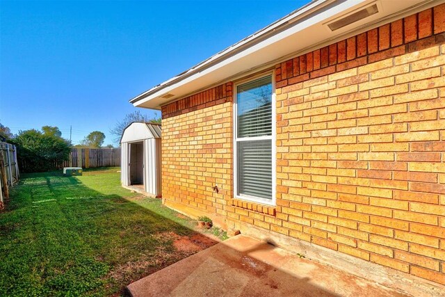 view of side of property featuring a yard and a storage unit