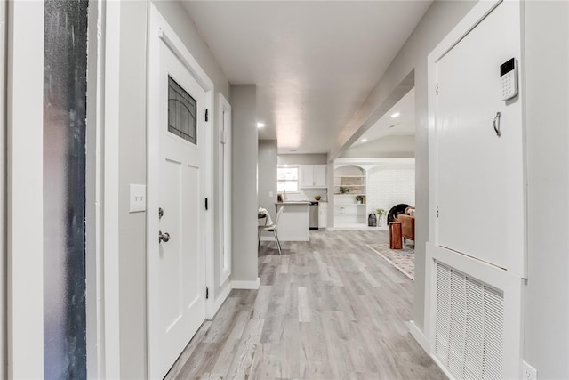 hall with light wood-type flooring and built in features