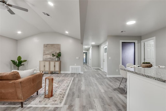 living room featuring light wood-type flooring, vaulted ceiling, and ceiling fan