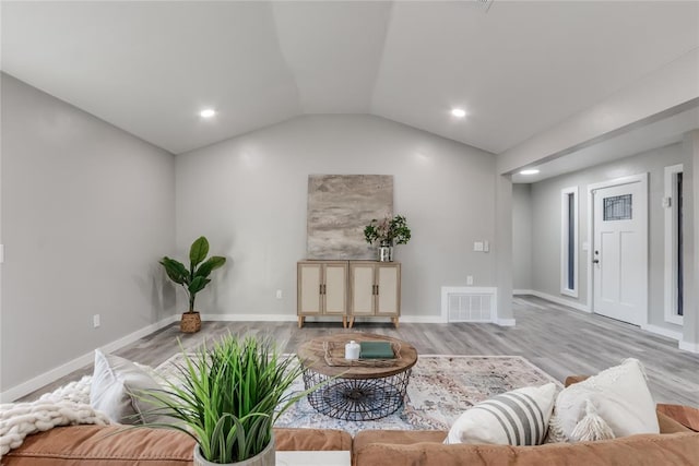 living room with light hardwood / wood-style flooring and lofted ceiling