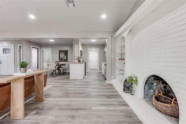 hallway with built in features and light hardwood / wood-style floors