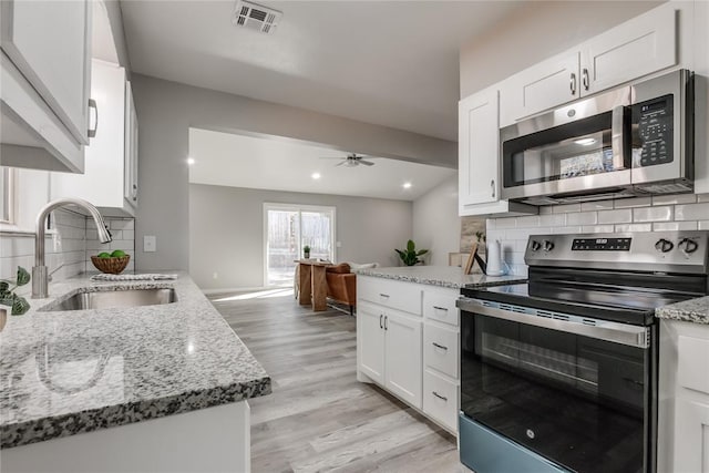 kitchen featuring tasteful backsplash, stainless steel appliances, ceiling fan, sink, and white cabinetry