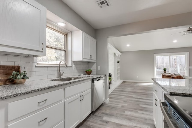 kitchen featuring sink, stainless steel dishwasher, light stone countertops, tasteful backsplash, and white cabinetry