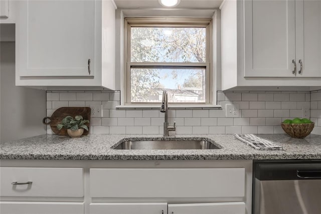 kitchen featuring dishwasher, backsplash, white cabinetry, and sink