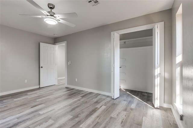 unfurnished bedroom with a closet, light hardwood / wood-style flooring, and ceiling fan