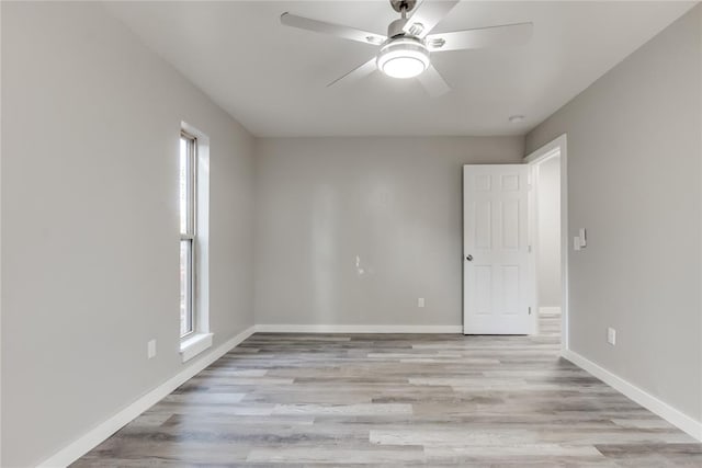 spare room with light wood-type flooring, a wealth of natural light, and ceiling fan