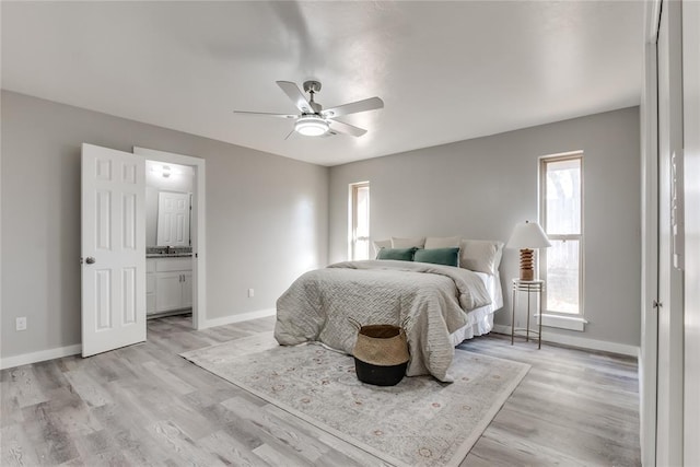 bedroom featuring light hardwood / wood-style flooring, ensuite bath, and ceiling fan