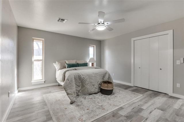 bedroom featuring ceiling fan, light hardwood / wood-style flooring, and a closet