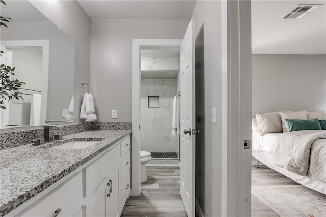 bathroom featuring vanity, toilet, wood-type flooring, and walk in shower