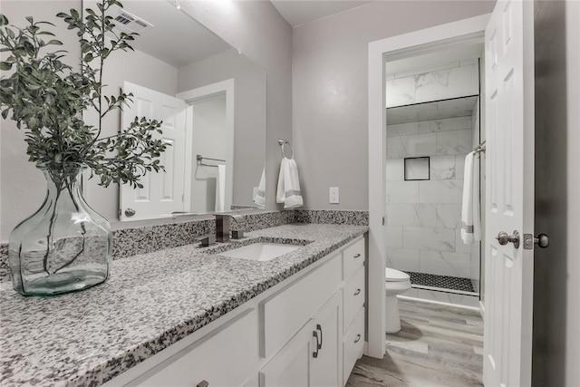 bathroom with vanity, hardwood / wood-style flooring, toilet, and walk in shower