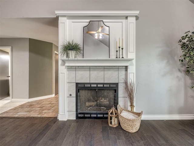 interior details with a tile fireplace and wood-type flooring