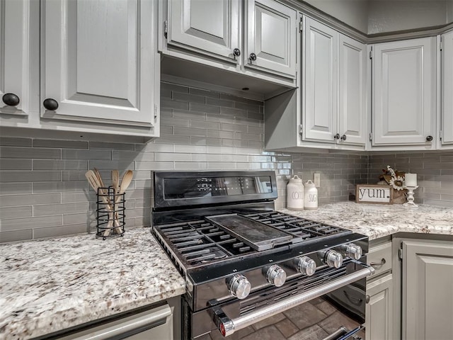 kitchen with appliances with stainless steel finishes, backsplash, and white cabinetry