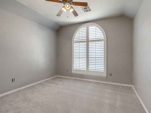 empty room with ceiling fan, light colored carpet, and vaulted ceiling