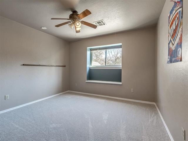 spare room featuring ceiling fan, carpet floors, and a textured ceiling