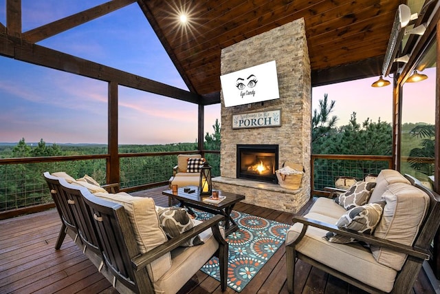 deck at dusk featuring an outdoor living space with a fireplace