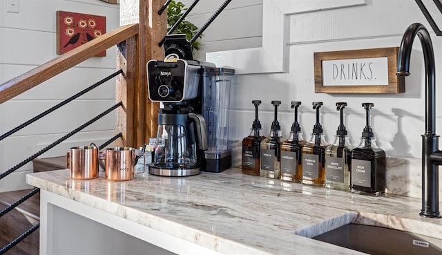 bar featuring light stone countertops and hardwood / wood-style flooring