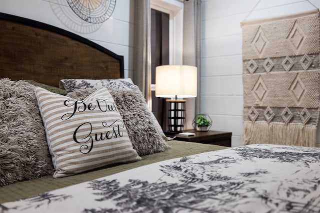 bedroom featuring wooden walls