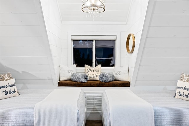 bedroom with wood walls and a notable chandelier