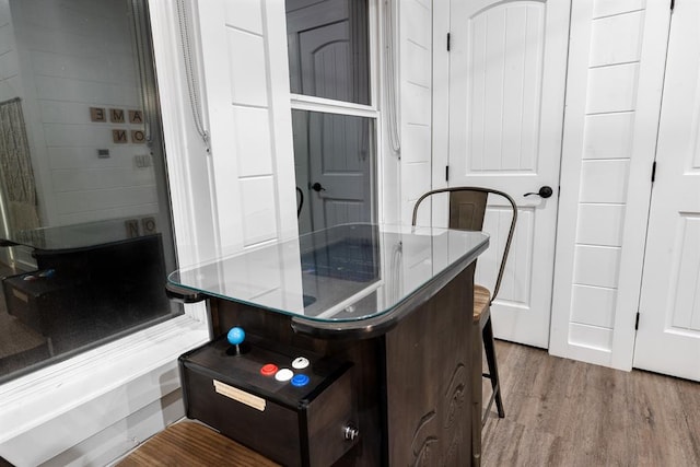 kitchen featuring hardwood / wood-style floors, dark brown cabinets, and a breakfast bar area