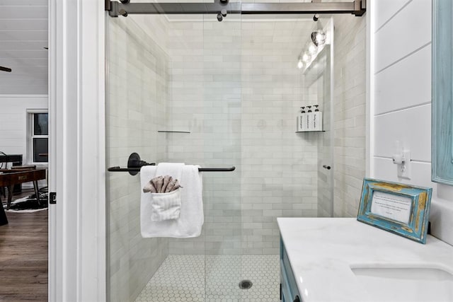 bathroom featuring wood-type flooring, vanity, and a shower with shower door