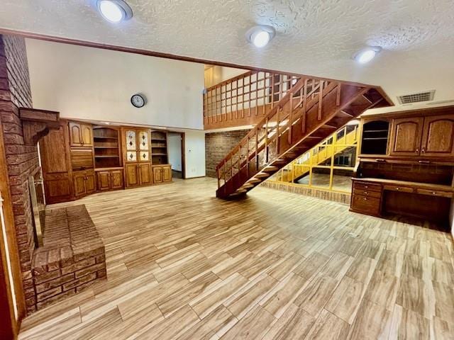 living room with vaulted ceiling, crown molding, a textured ceiling, and hardwood / wood-style flooring