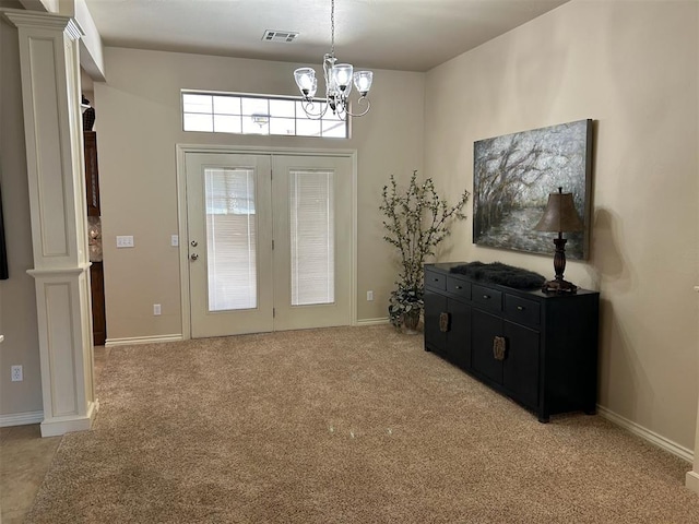 foyer entrance featuring light carpet and an inviting chandelier