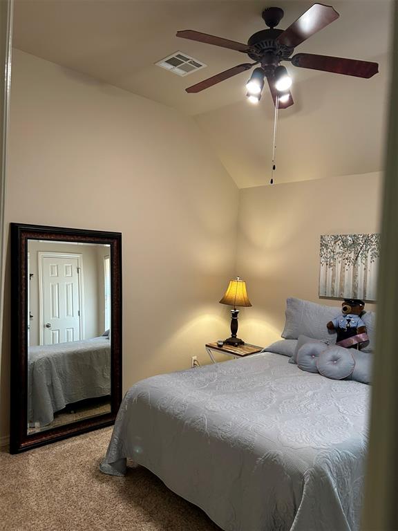 bedroom with ceiling fan, carpet, and lofted ceiling