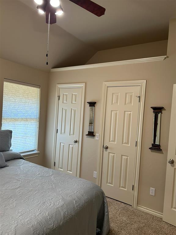 bedroom with ceiling fan, carpet, and lofted ceiling