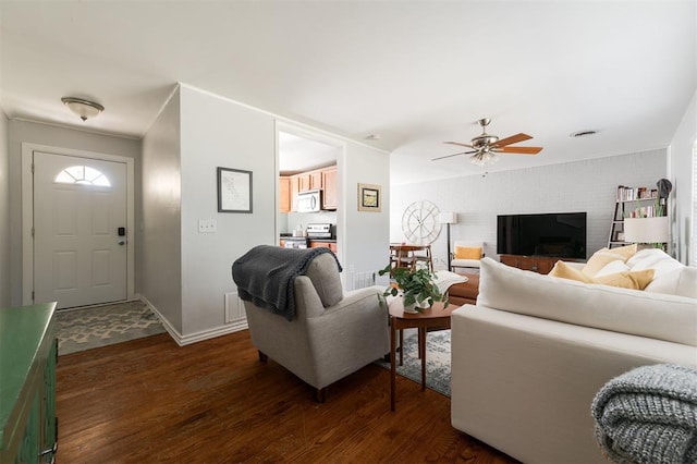 living room featuring dark hardwood / wood-style flooring, a fireplace, and ceiling fan