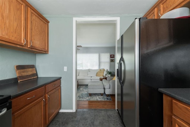 kitchen featuring electric range oven and stainless steel refrigerator with ice dispenser