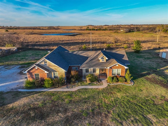 view of front of home with a front lawn and a rural view