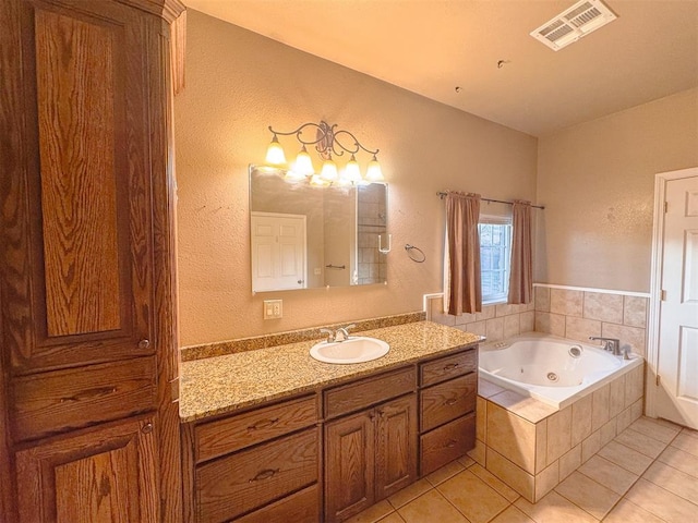 bathroom with tile patterned floors, vanity, and tiled bath