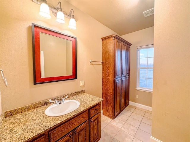 bathroom featuring tile patterned flooring, vanity, and a textured ceiling