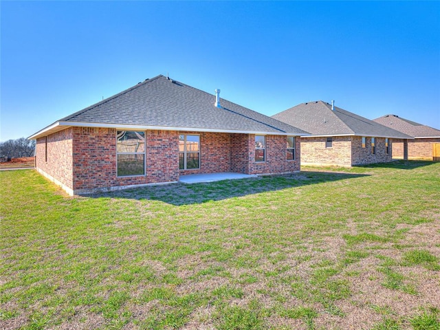 back of house with a patio area and a yard