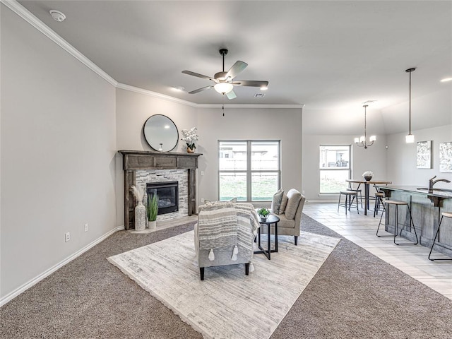 living room featuring light carpet, ceiling fan with notable chandelier, a stone fireplace, sink, and crown molding