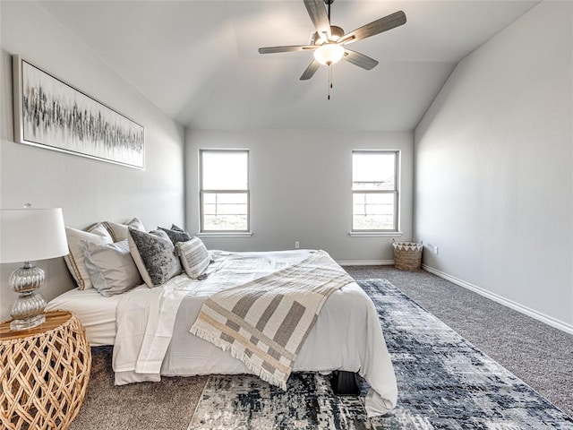 bedroom featuring multiple windows, ceiling fan, dark carpet, and vaulted ceiling