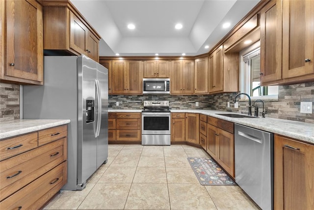 kitchen with light stone countertops, sink, lofted ceiling, and stainless steel appliances